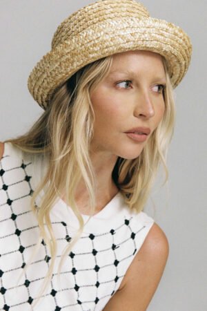 Model wearing the Ahoy Boater hat, a natural straw hat with a textured design.