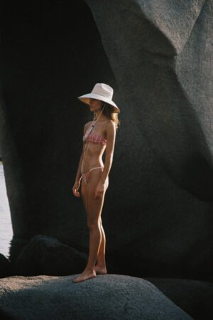 Model wearing The Vista straw cowboy hat on rocky beach