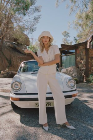 Model wearing a beige Wave Bucket Hat, standing next to a vintage car in a natural setting.