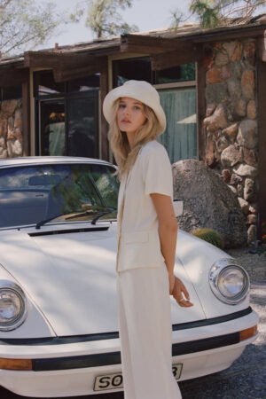 Model wearing a beige Wave Bucket Hat in front of a vintage car