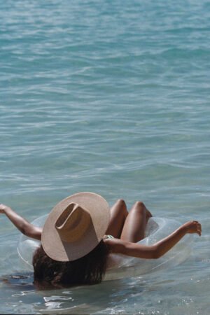 Person relaxing in water wearing a wide-brimmed straw cowboy hat